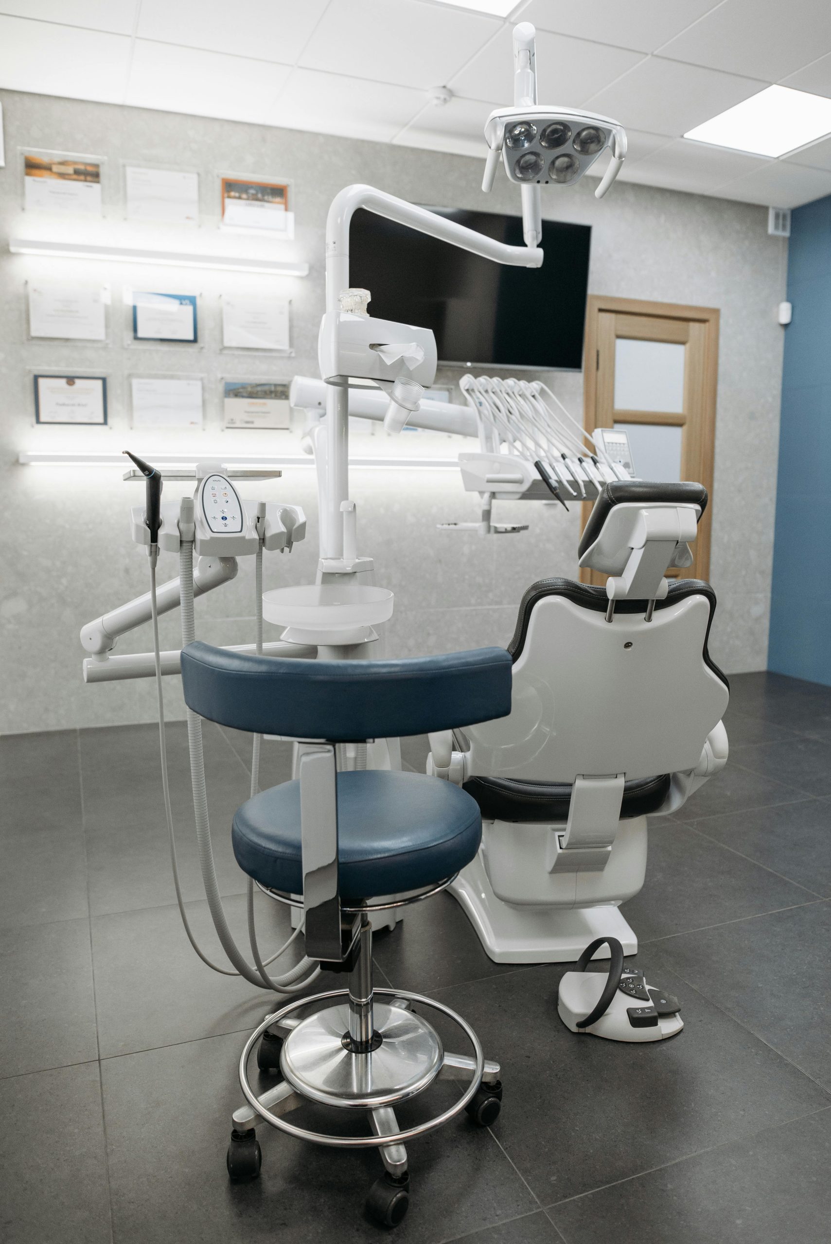 Clean and contemporary dentist office with modern equipment and empty chair, ready for patients.